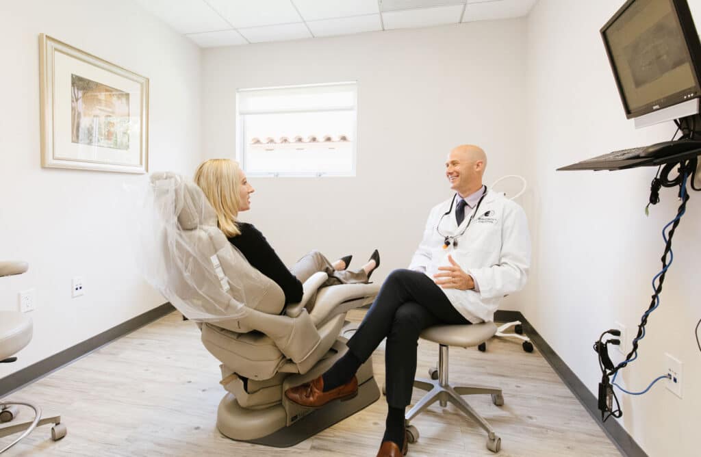 Dr. Sten Ericson discussing dental treatment with a patient in an exam room