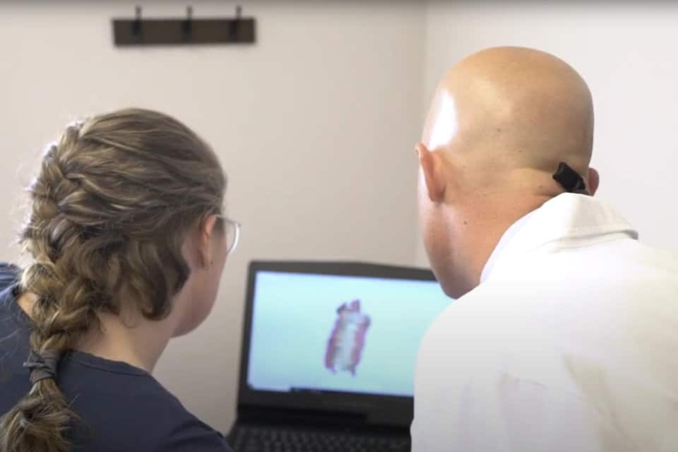 an orthodontist and his assistant viewing a patient's 3d scans on a monitor
