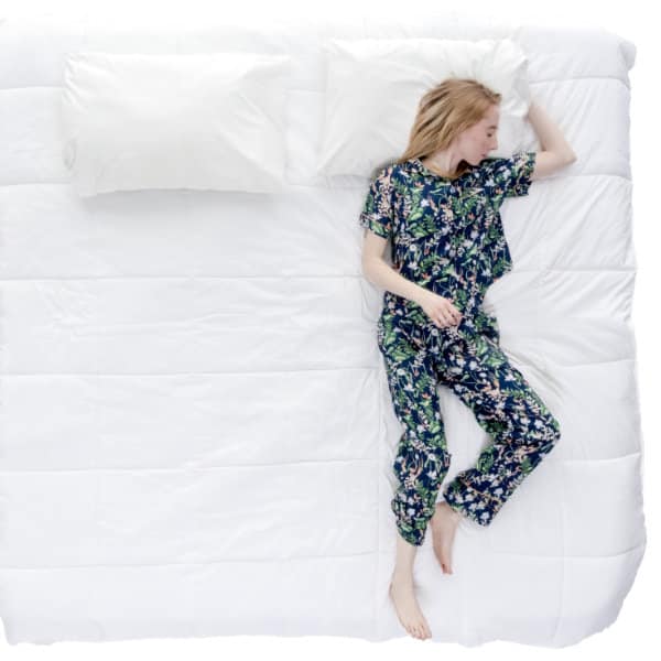 a woman with sleep apnea sleeping on a large bed