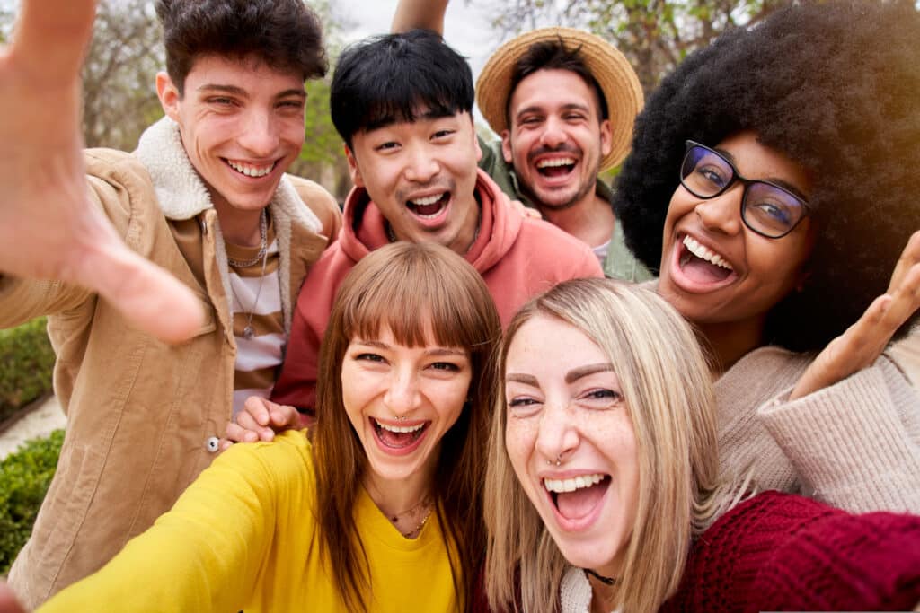 Diverse group of 6 young adults smiling in a selfie