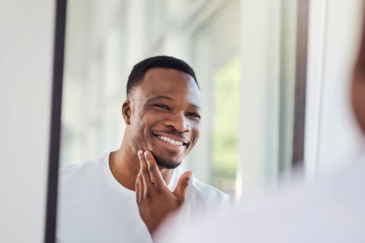 Man proudly examining his teeth in the mirror in the morning