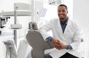 Highly qualified young black dentist posing at clinic over modern cabinet
