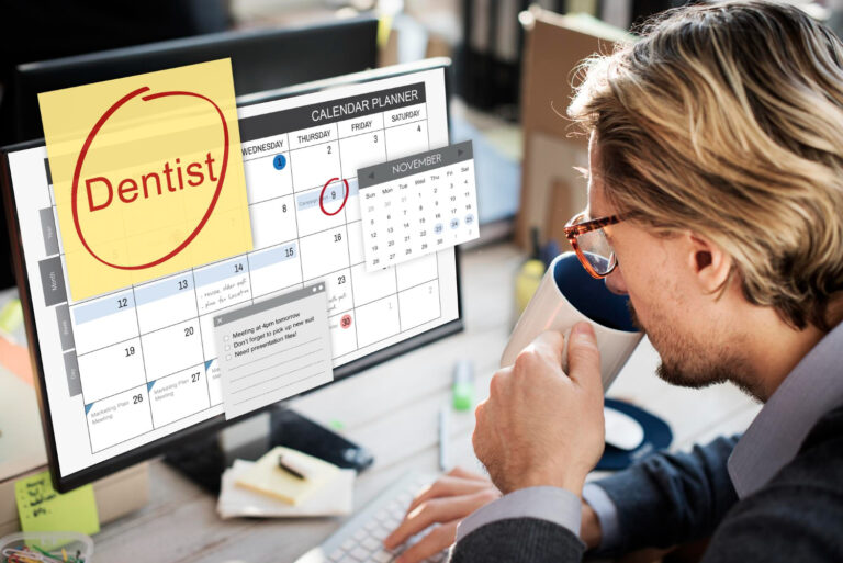 A person sits at a desk, looking at a computer screen displaying a November calendar with various tasks and appointments highlighted. A red-circled sticky note reads "Dentist," and the 6th is marked in red on the mini-calendar.