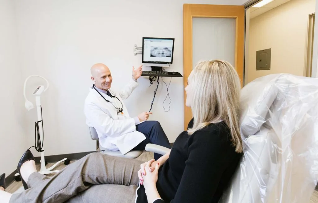 Dr. Ericson showing a patient her x-rays as she sits in a dental chair