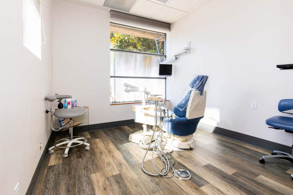 patient room with a dental chair, hygienist stool, dental tools